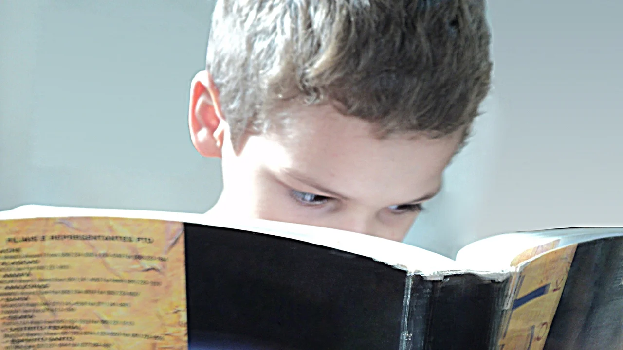 blue bowl of black bean beef tortilla soup on a board with cilantro and shredded cheese in background